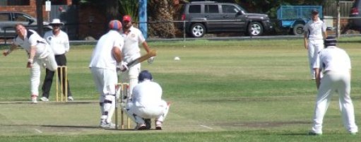 Umpire Brian Lazzaro watches intently as Simon Thornton bowls. Peter Golding's behind the stumps, with Jack Newman at cover and Ben Thomas at slip.