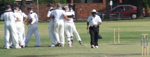 The players are ecstatic at the fall of Maribyrnong Park's final wicket, as umpire Lucky Mendis walks down the pitch.